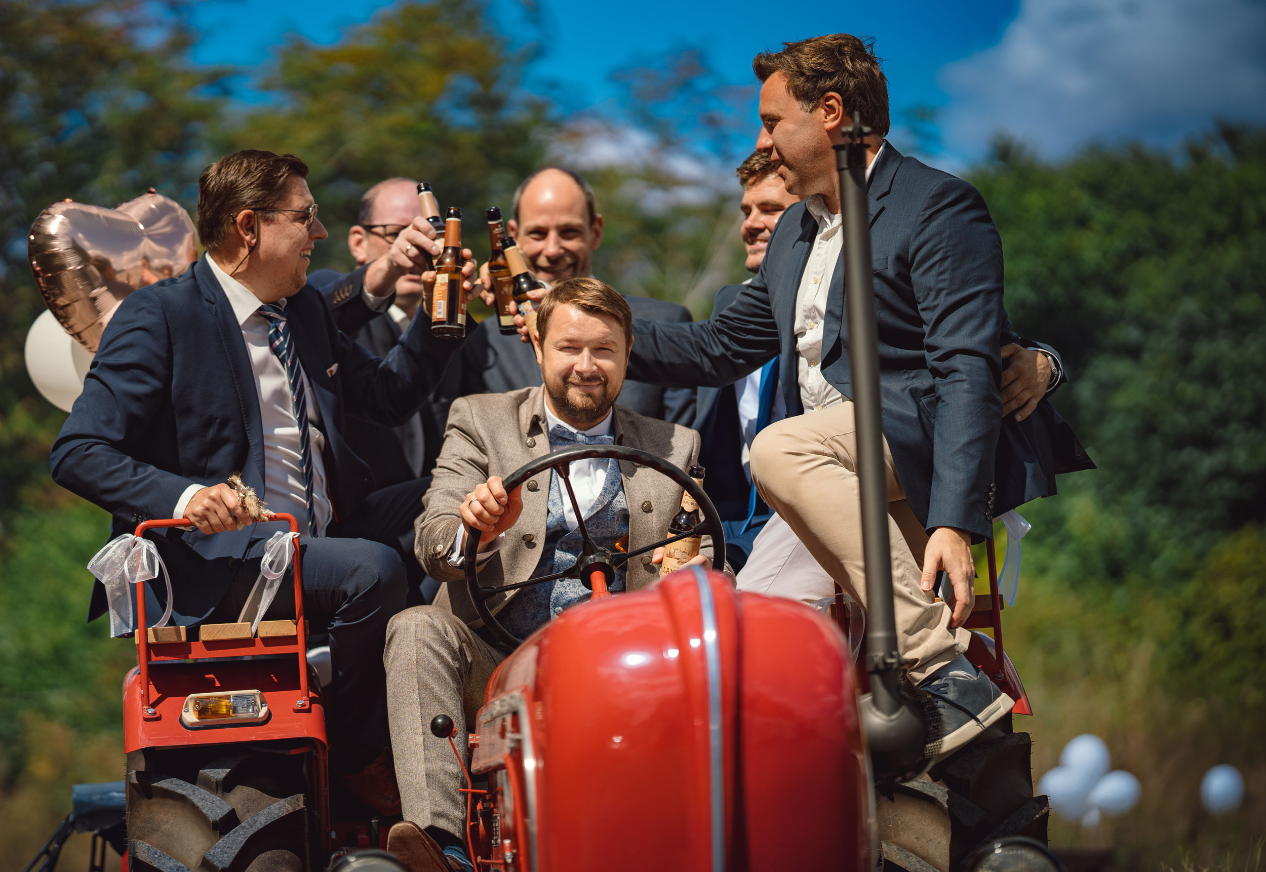 Hochzeitsgesellschaft auf rotem Traktor