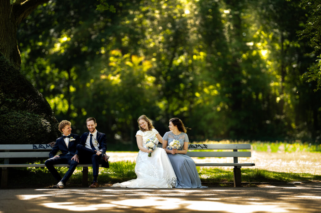 Maleen und Simon bei ihrer Hochzeit auf einer Bank im Grünen